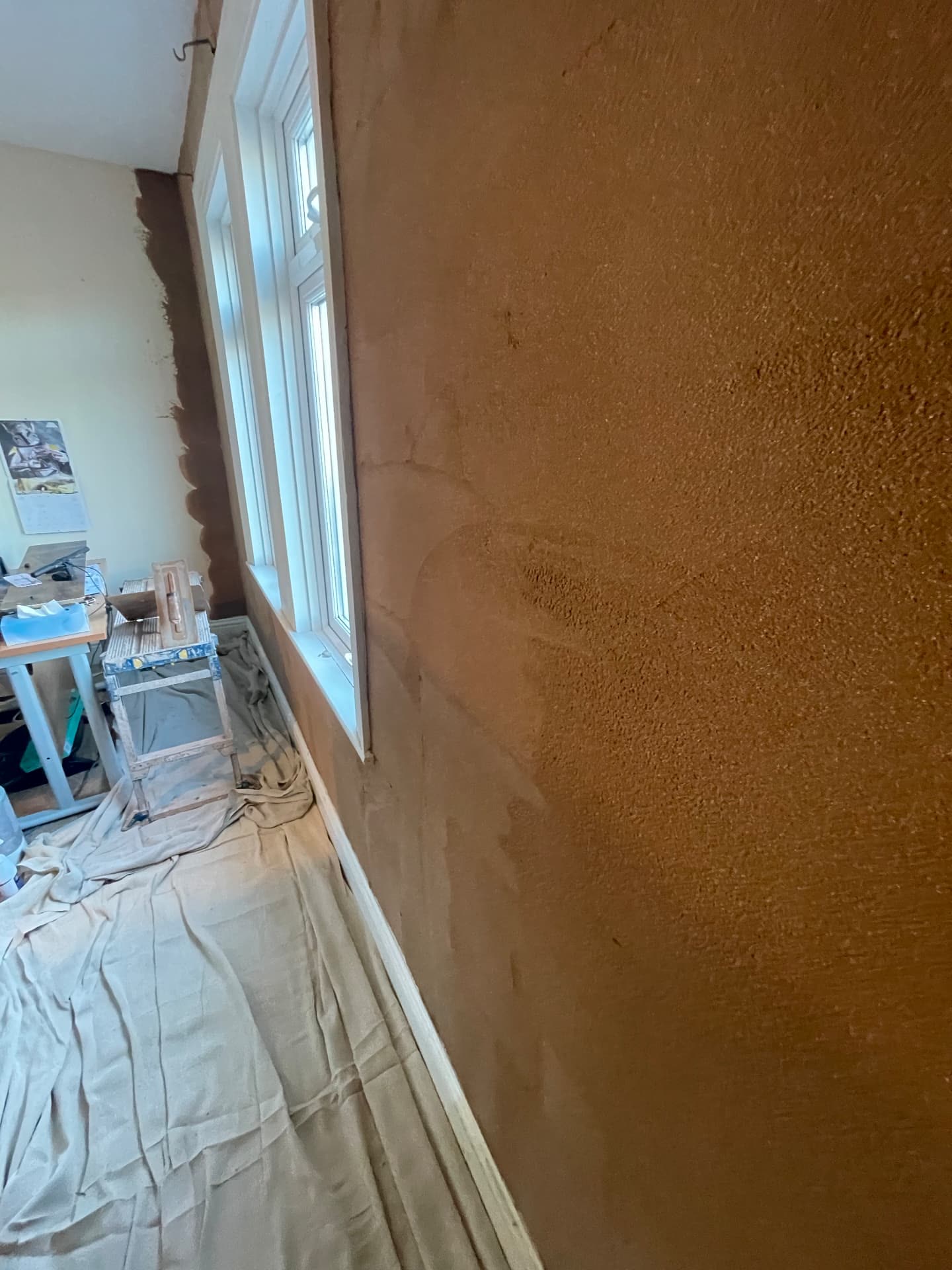 Textured cork insulation coat applied to an internal wall around a window