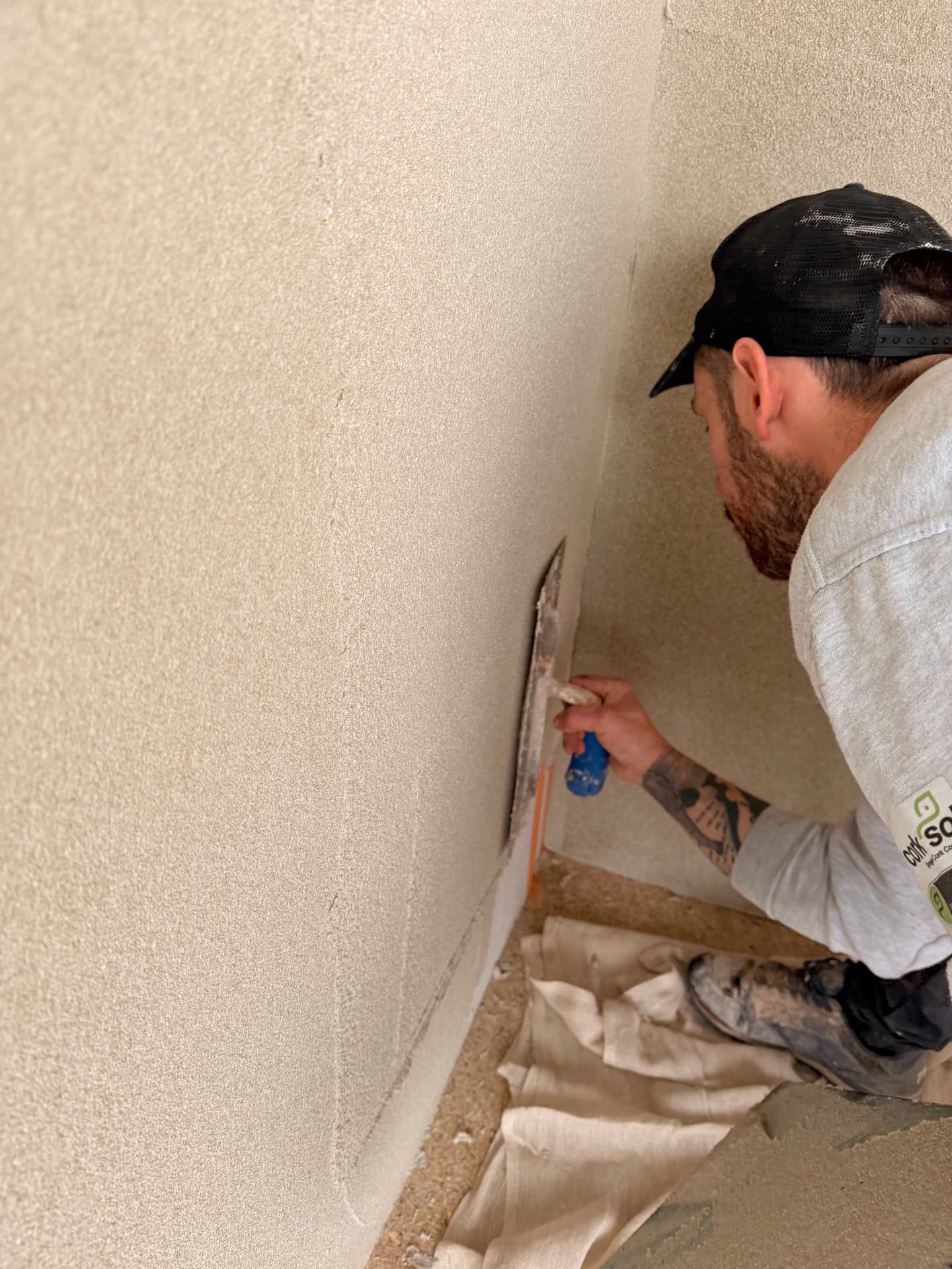 Cork insulation coating being trowelled onto an internal wall