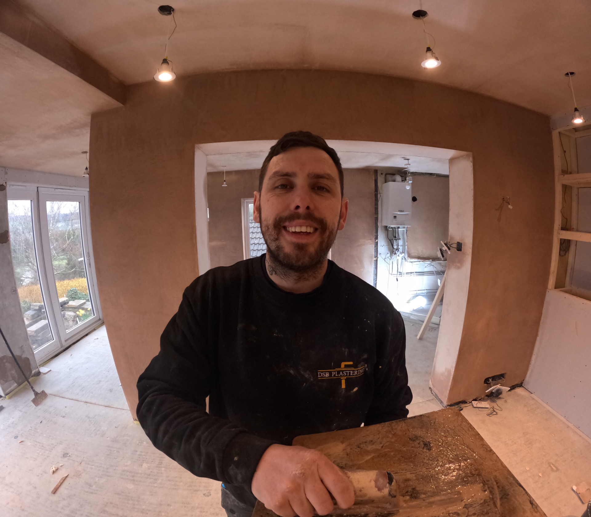 Dan Bunce of DSB Plastering & Wall Insulation in a room being plastered