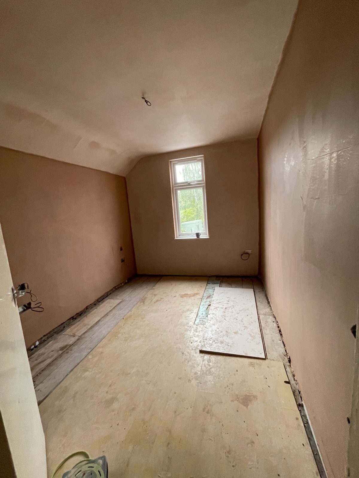Bedroom walls and window reveal freshly plastered and left clean