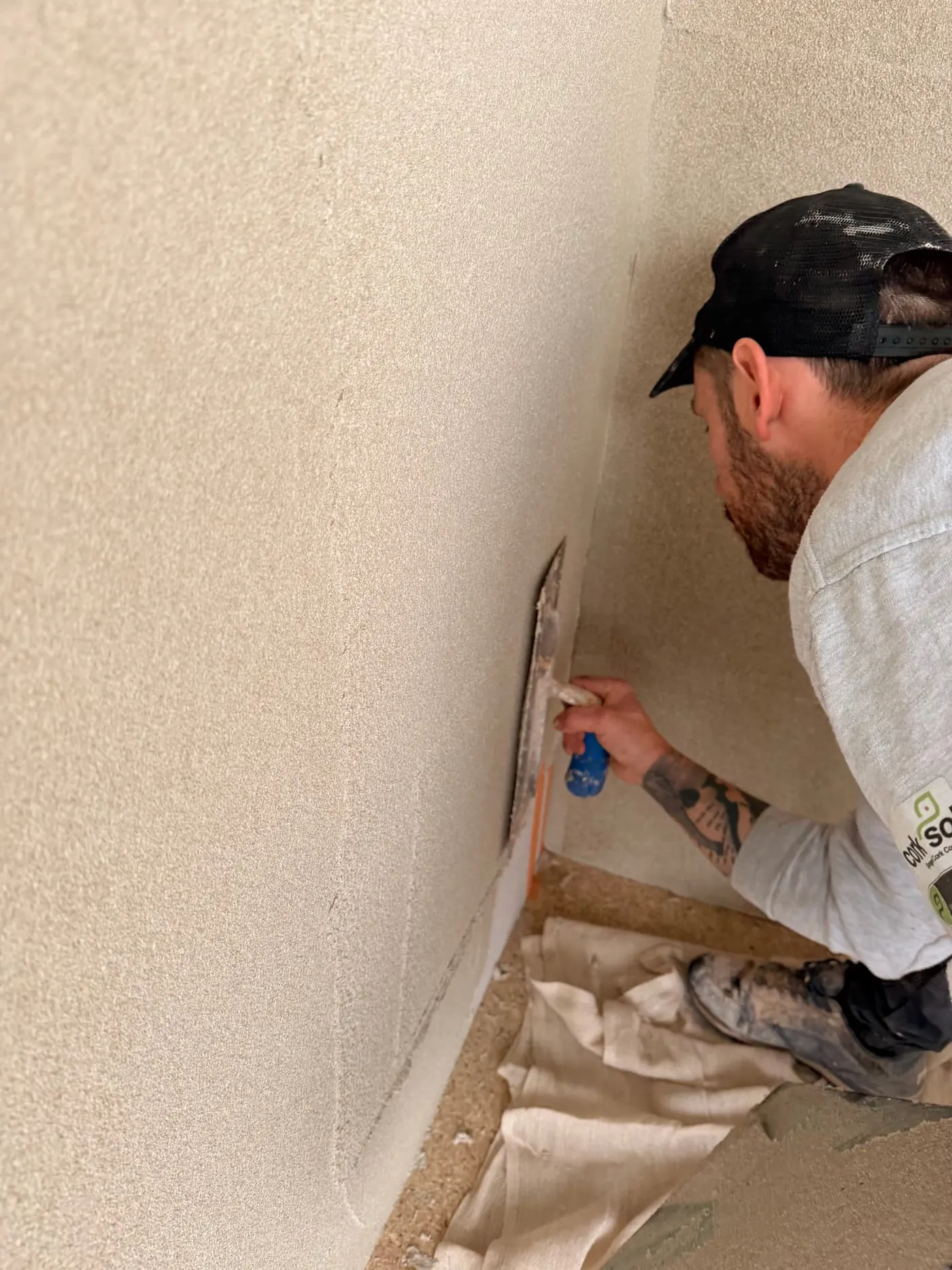 DSB installer applying AeroCork insulation to a cold internal wall in Bath